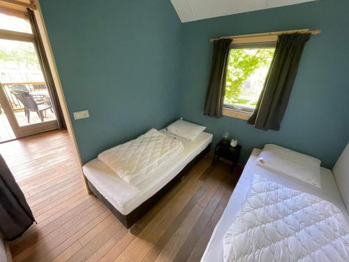 een slaapkamer met 2 bedden en een spiegel bij Trekkershut - 4 personen in Beilen
