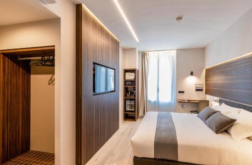 a bedroom with a large white bed and a television at Aiello Hotels - Duomo in Milan