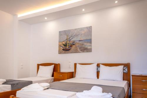 two beds in a room with a painting on the wall at Azzurro in Paleros