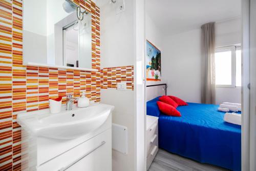 a small bathroom with a sink and a bed at La Terrazza Sul Porto in San Foca