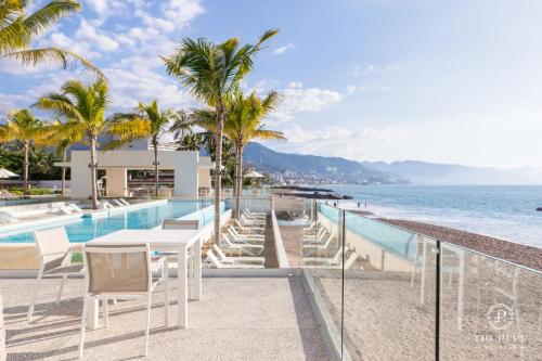 a resort with a swimming pool and a beach at Harbor Puerto Vallarta 1006 in Puerto Vallarta