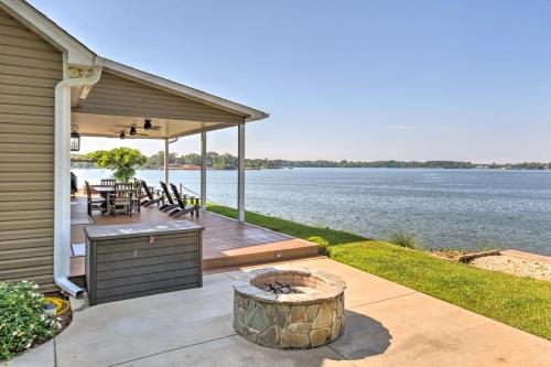 a deck with a grill and a view of the water at Elegant Lakefront Gem with Dock and Sunset Views! in Cross Hill