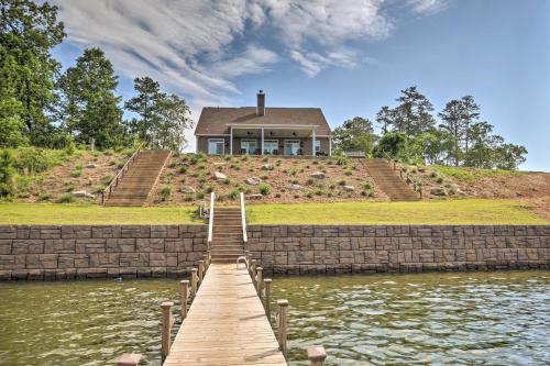 a house on top of a hill with a wooden dock at Elegant Lakefront Gem with Dock and Sunset Views! in Cross Hill