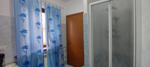 a shower in a bathroom with a blue shower curtain at La Casa di Alberto in Camerino