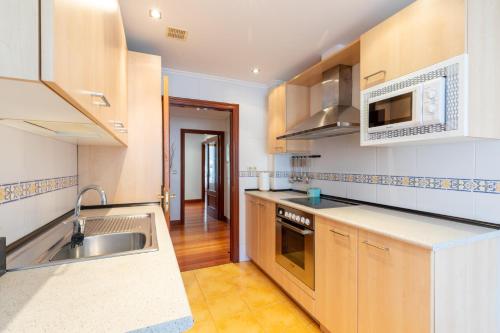 a kitchen with a sink and a stove top oven at Sabea - Baskey Rentals in Iraeta