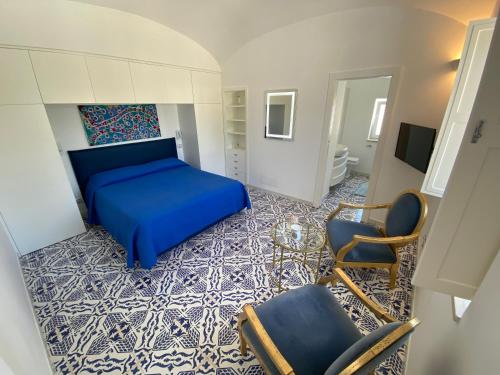 a bedroom with a blue bed and a chair at Villa Raffaella in Capri