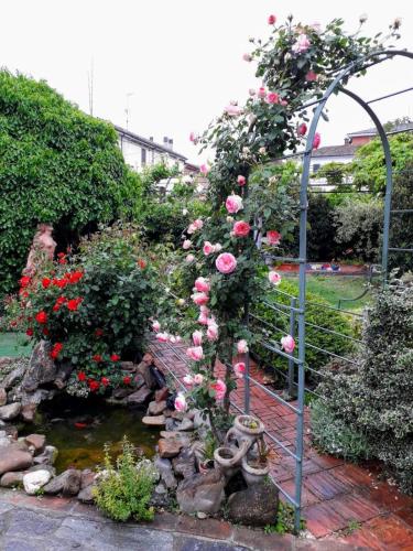 a garden with roses and a bridge with a pond at villart in Carbonara Scrivia