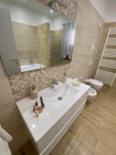 a bathroom with a sink and a toilet and a mirror at Caia Appartamenti Tropea in Tropea