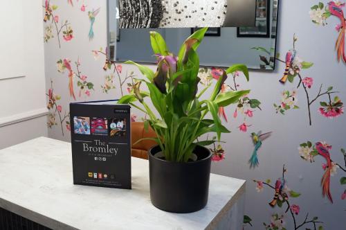 un libro seduto su un tavolo accanto a una pianta in vaso di The Bromley a Blackpool