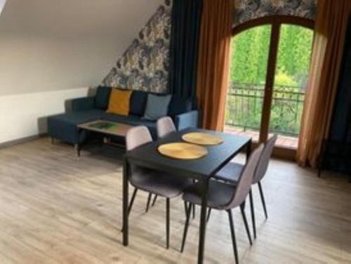 - un salon avec une table, des chaises et un canapé dans l'établissement Apartamenty Brzozowe Zacisze, à Duszniki-Zdrój