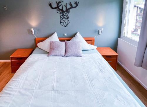 um quarto com uma grande cama branca e duas mesas em swissme - 100qm - Balkon - 2 Bäder - Parkplatz - Fußbodenheizung em St. Moritz