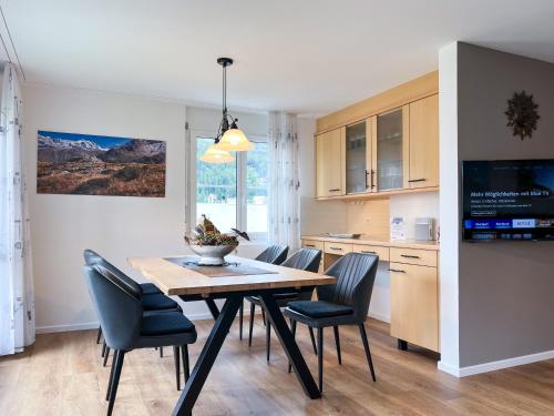 eine Küche und ein Esszimmer mit einem Tisch und Stühlen in der Unterkunft swissme - 100qm - Balkon - 2 Bäder - Parkplatz - Fußbodenheizung in St. Moritz