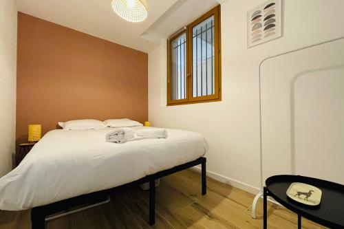 une chambre avec un lit, une table et une fenêtre dans l'établissement Le Chenonceau  Charme et douceur Tourangelle, à Tours