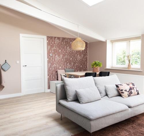 a living room with a couch and a table at Het Veldhuis in Beuningen