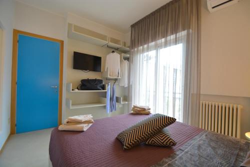 een slaapkamer met een paars bed met handdoeken erop bij Prime Blue Suite - Bilocale in Riccione