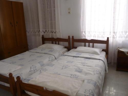 two twin beds in a bedroom with a window at Electra in Líndos