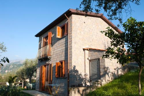 uma casa de tijolos com uma varanda ao lado em Agriturismo L'Olivara em Piano di Sorrento