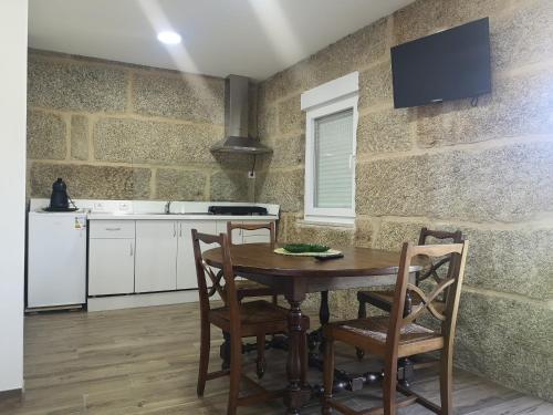 uma cozinha com mesa e cadeiras num quarto em 5 Cinco em Chaves