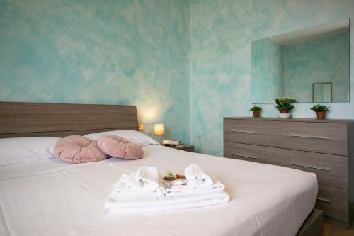 1 dormitorio con cama con almohadas rosas y espejo en AM apartment, en Pianella