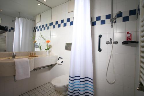 uma casa de banho com um chuveiro, um WC e um lavatório. em Nigel Restaurant & Hotel im Wendland em Bergen an der Dumme
