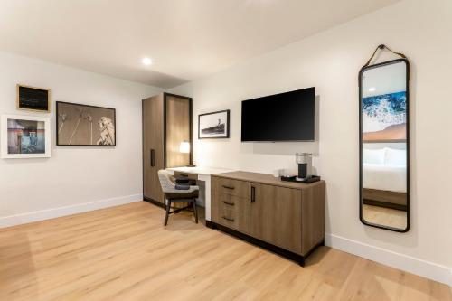 a room with a desk and a television on a wall at Del Mar Beach Hotel in San Diego