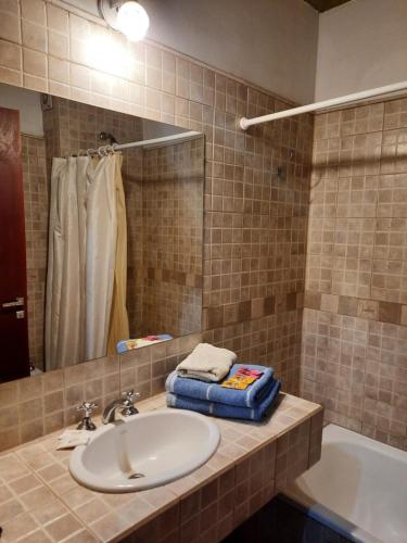 La salle de bains est pourvue d'un lavabo, d'une baignoire et d'un miroir. dans l'établissement La Posada de la Calandria, à Purmamarca