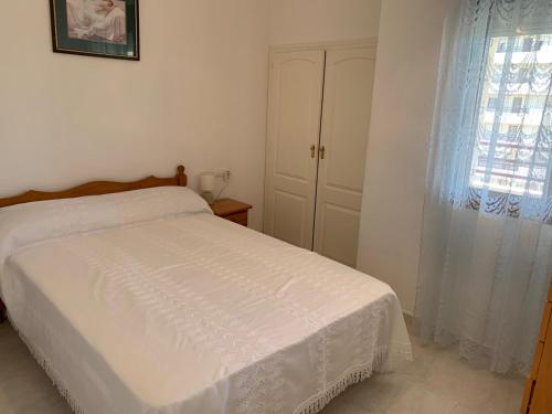 a bedroom with a white bed and a window at SERVICE APART LAZARO TOPACIO 3 in Calpe