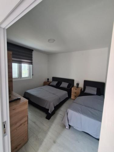 een slaapkamer met 2 bedden en een dressoir bij Apartment Nikčević in Tivat