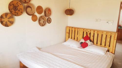 Schlafzimmer mit einem Bett mit einem Kopfteil aus Holz in der Unterkunft Bluesea Homestay in Phu Yen