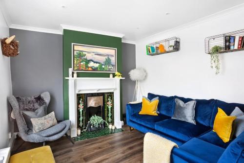 - un salon avec un canapé bleu et une cheminée dans l'établissement Stunning 4Bed Townhouse by HIC & Trendy Kings Quarter!, à Harrogate