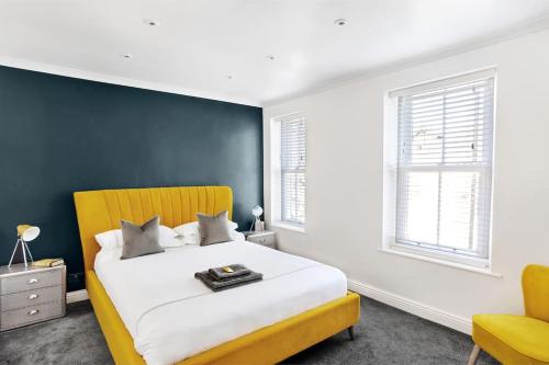 - une chambre avec un lit et une chaise jaune dans l'établissement Stunning 4Bed Townhouse by HIC & Trendy Kings Quarter!, à Harrogate