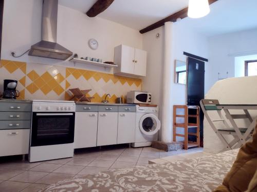 a kitchen with a stove and a washing machine at Studio Genêt Verdon Provence in Riez