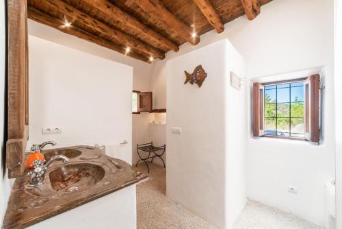 a bathroom with a sink and a window at CAN FARITZEO in Sant Rafael de Sa Creu