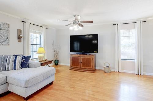 a living room with a couch and a flat screen tv at Whispering Palms in Dauphin Island