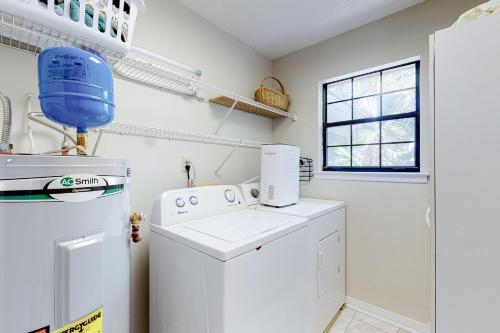 a white laundry room with a washer and dryer at Whispering Palms in Dauphin Island