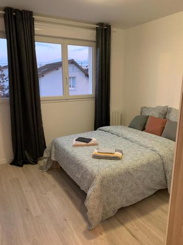 ein Schlafzimmer mit einem Bett und einem großen Fenster in der Unterkunft Villa Tenjin Chambre 1 in Bondy