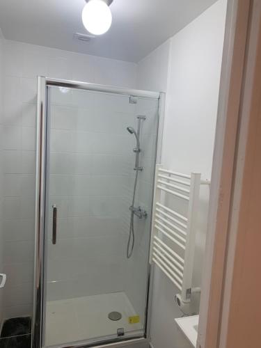a shower with a glass door in a bathroom at Villa Tenjin Chambre 1 in Bondy