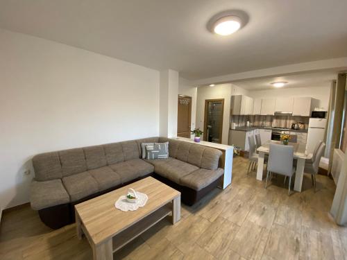 uma sala de estar com um sofá e uma mesa em Kraljević Apartments em Vrh