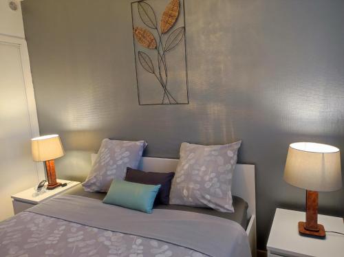 a bedroom with a bed with pillows and two lamps at Le balcon de la basse centre ville de Perpignan in Perpignan