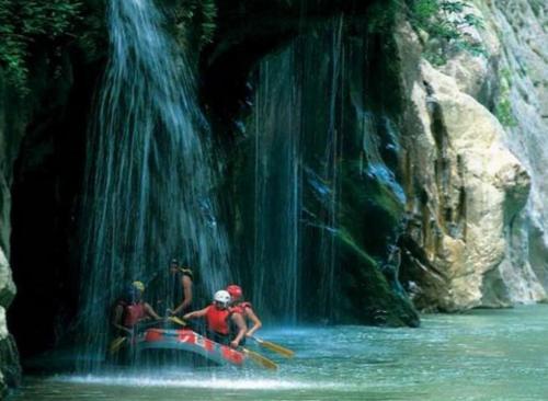 a group of people on a raft in front of a waterfall at ΕΚΑLI ROOMS APARTMENTS in Kalentzi