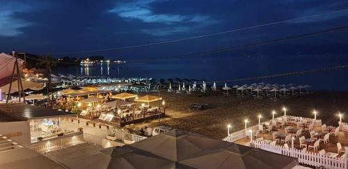 a view of a beach at night with chairs and umbrellas at Aqua Luxury Suites by Estia in Roda