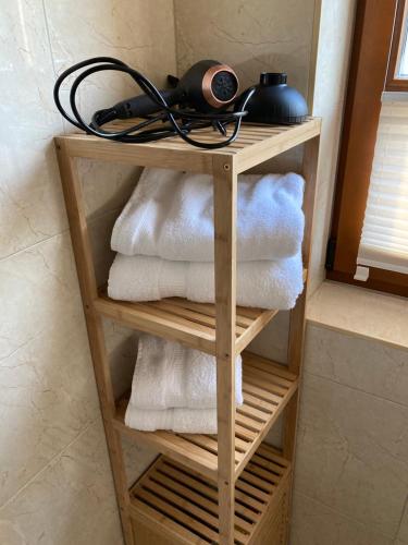 a towel rack with towels and a hair dryer on top at Strand24 in Ostseebad Nienhagen