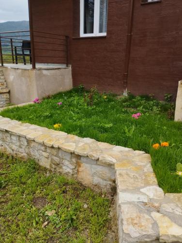 a stone retaining wall in front of a house at ΕΚΑLI ROOMS APARTMENTS in Kalentzi