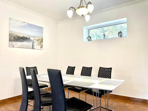 a dining room with a white table and chairs at Holiday home with Jakuzzi and Sauna in Kisoroszi