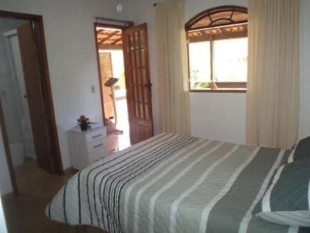 sypialnia z dużym łóżkiem i oknem w obiekcie Tabarka Lodge w mieście Nova Friburgo