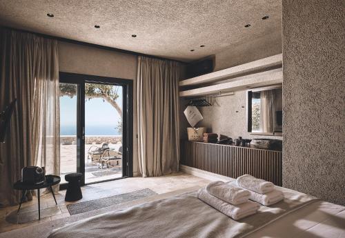 a bedroom with a bed and a view of the ocean at Noma Milos - Delmar Collection in Provatas
