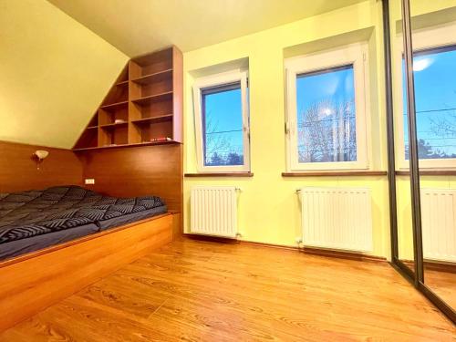 a bedroom with a bed and three windows at Holiday home with Jakuzzi and Sauna in Kisoroszi