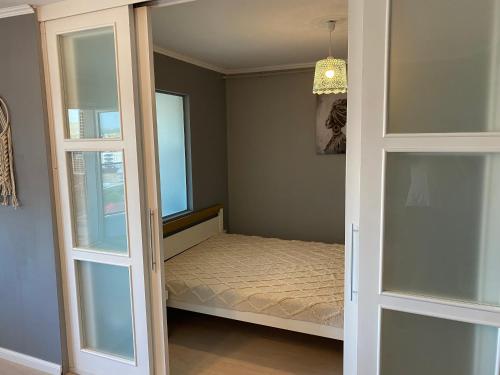 Habitación pequeña con cama y puertas de cristal en Grandpa Ope en Cluj-Napoca