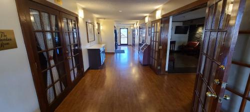 an empty hallway with wooden floors and wooden doors at Red Roof Inn & Suites Cornelius - Lake Norman in Cornelius