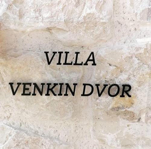 un mur en pierre avec les mots vania venna dye dans l'établissement Villa Venkin Dvor, à Novalja